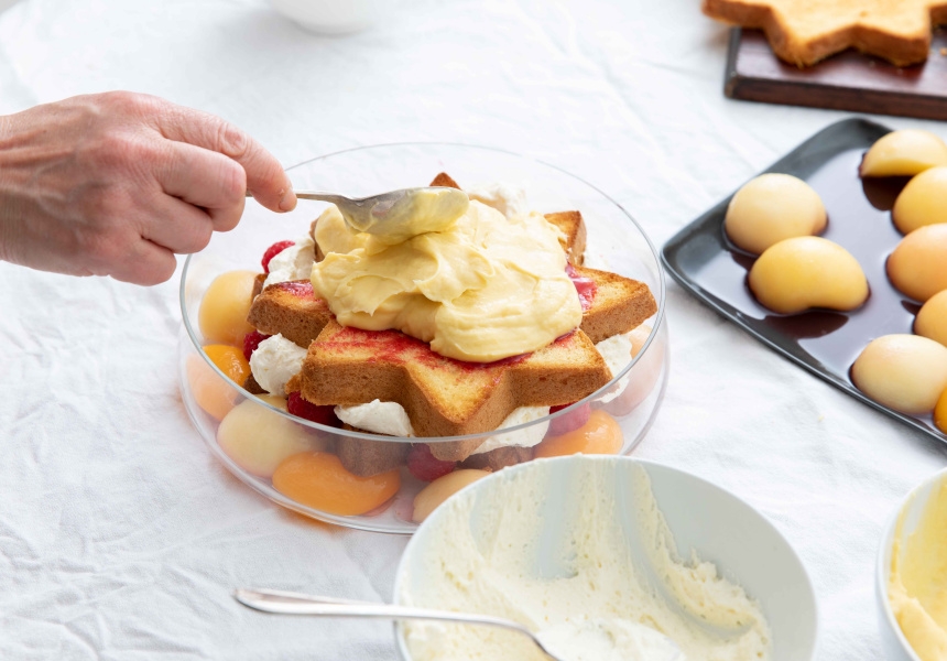 Place a smaller pandoro slice onto the whipped cream. Add more jam, vin santo, custard and peaches, in that order. Raspberries can be added wherever you like, but as before tend to fit nicely between the star-points of the cake. 
